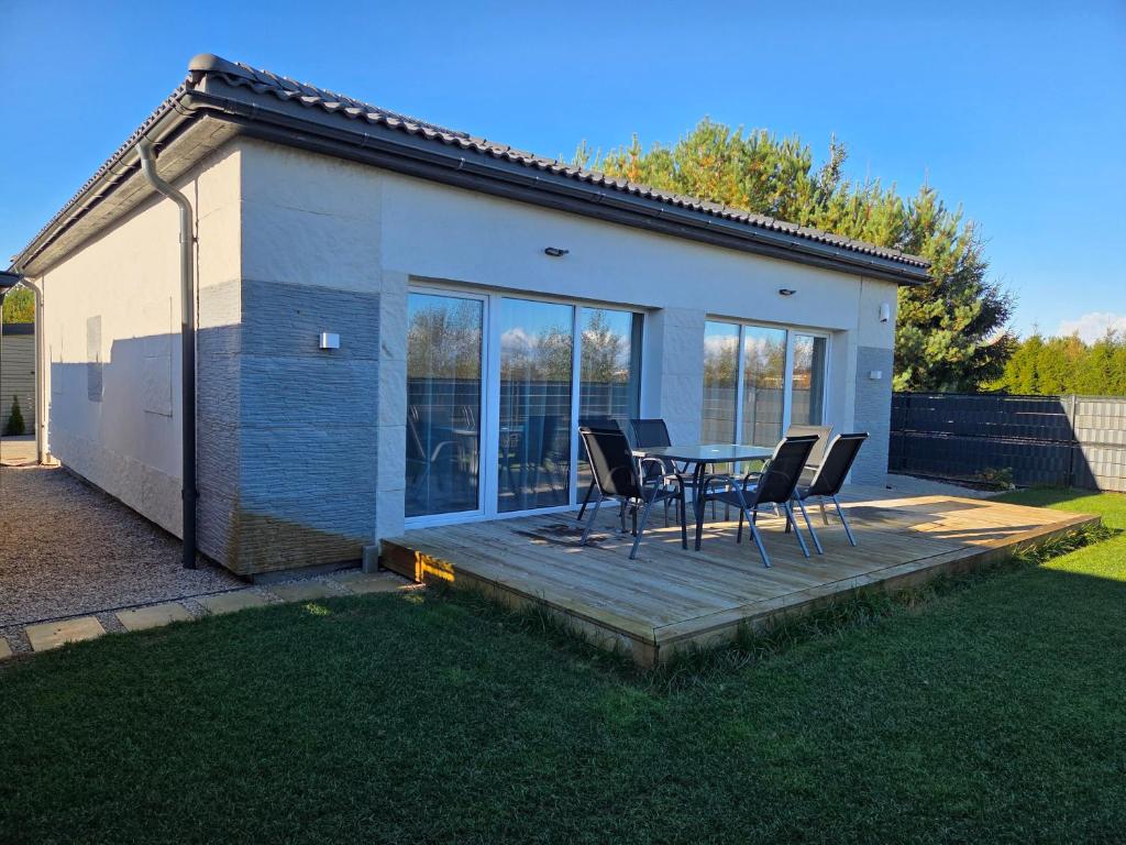 a patio with a table and chairs on a deck at Svečių namas in Radailiai
