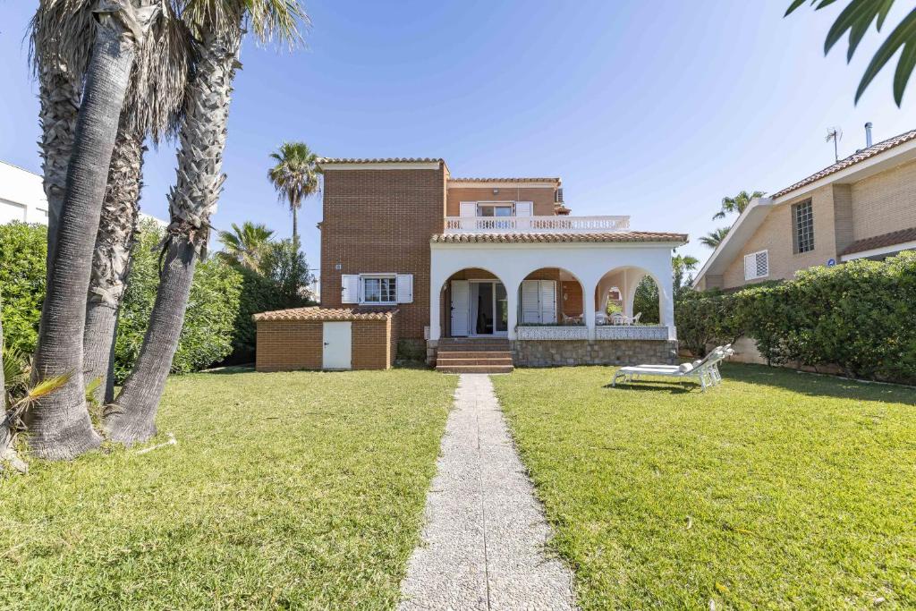 ein Haus mit Palmen im Hof in der Unterkunft Almarda Beach House in Almardá