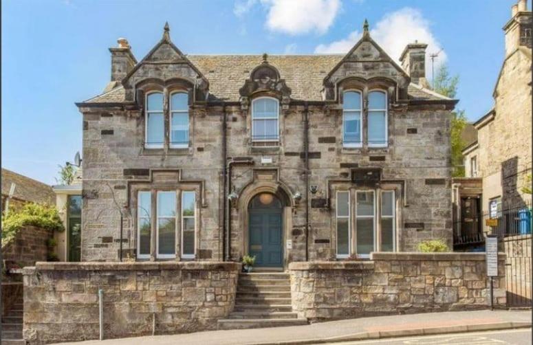 an old stone house with a blue door at Bruce on the Row-Historic Elegance near Edinburgh in Dunfermline