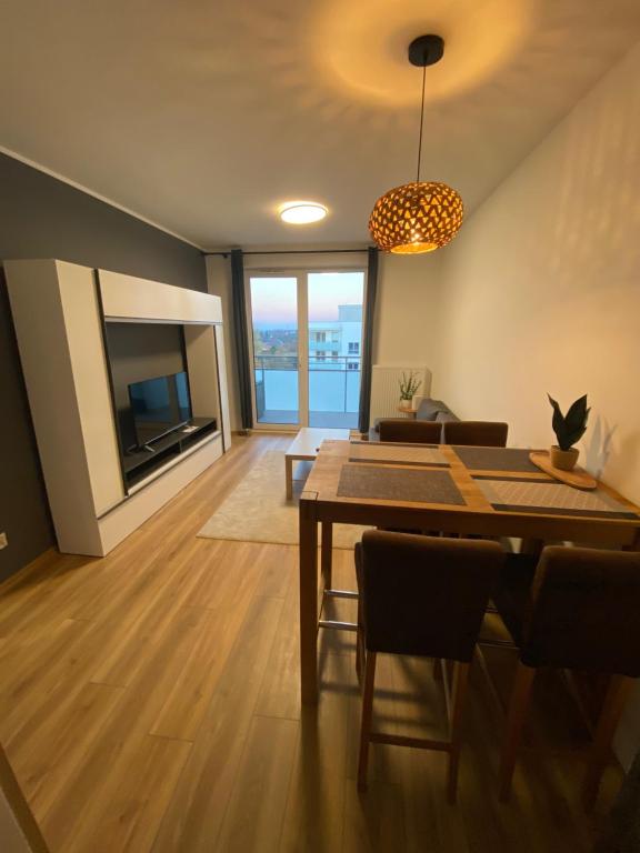Una sala de estar con una mesa de comedor y un televisor. en Nowy Apartament 4 Osob dobra lokalizacja Franciszkanska 300m z S6, en Koszalin