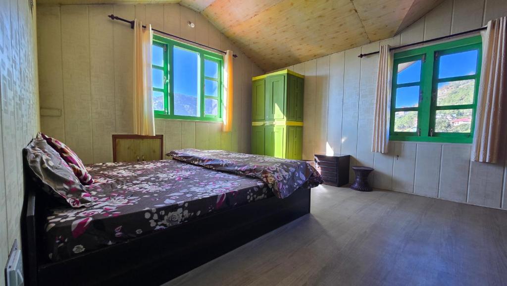 een slaapkamer met een bed in een kamer met ramen bij The City Escape Farmstay in Shimla