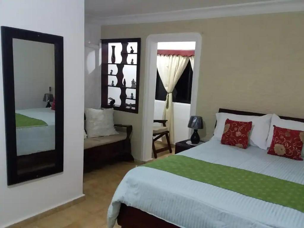 a bedroom with a large bed and a mirror at Puerto Plata Home in San Felipe de Puerto Plata