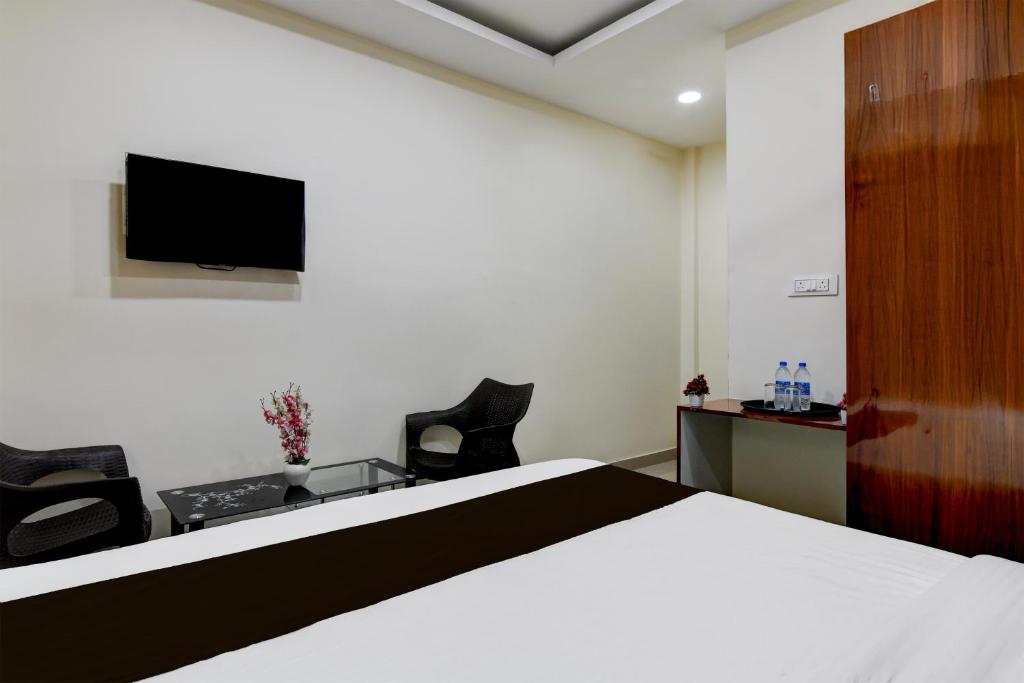 a bedroom with a bed and a tv on the wall at Hotel O SS INN in Bhubaneshwar