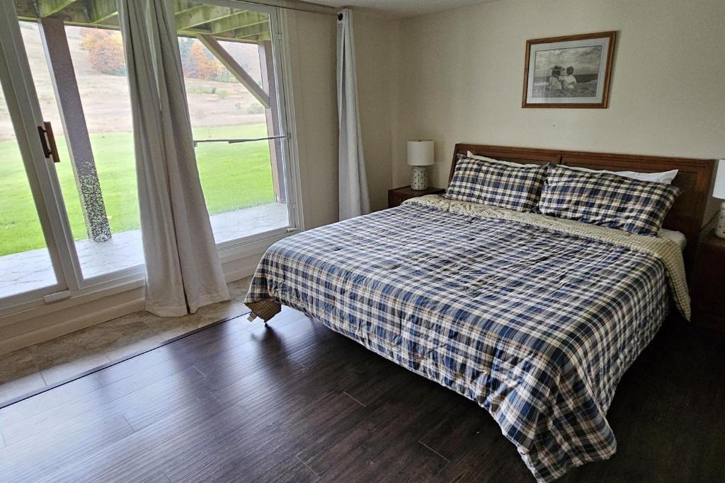 a bedroom with a bed with a plaid blanket and a window at Sugar Baby (B6) in Cedar