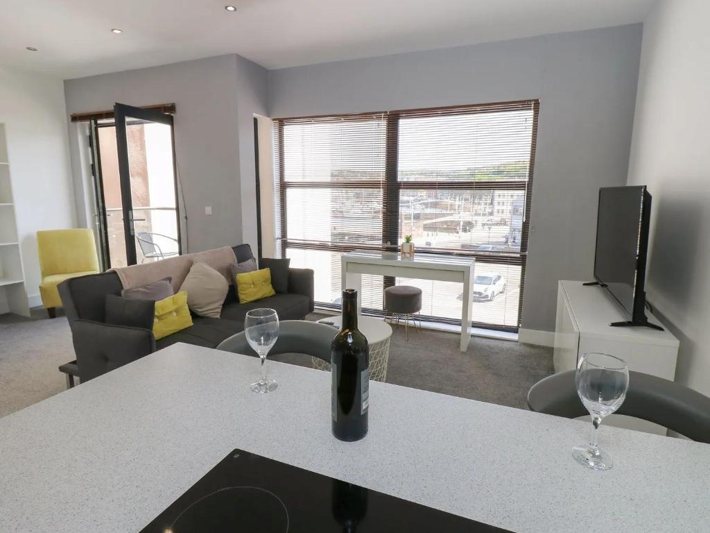 ein Wohnzimmer mit einer Flasche Wein auf einem Tisch in der Unterkunft Harbourside Apartment - 1 Bedroom - Sleeps 2 in Whitehaven