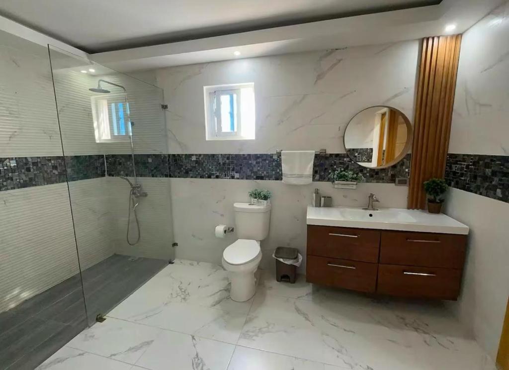 a bathroom with a toilet and a sink and a shower at Villa Lujosa en Boca Chica in Cuevas