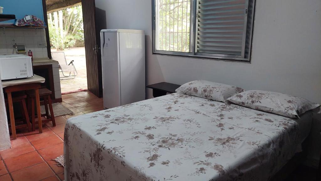 a bedroom with a bed and a refrigerator at Casa a 130 metros da praia de Boiçucanga in São Sebastião