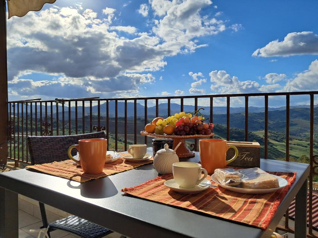 LeonforteにあるA casa do Caliaruのバルコニーにテーブルとフルーツの盛り合わせ