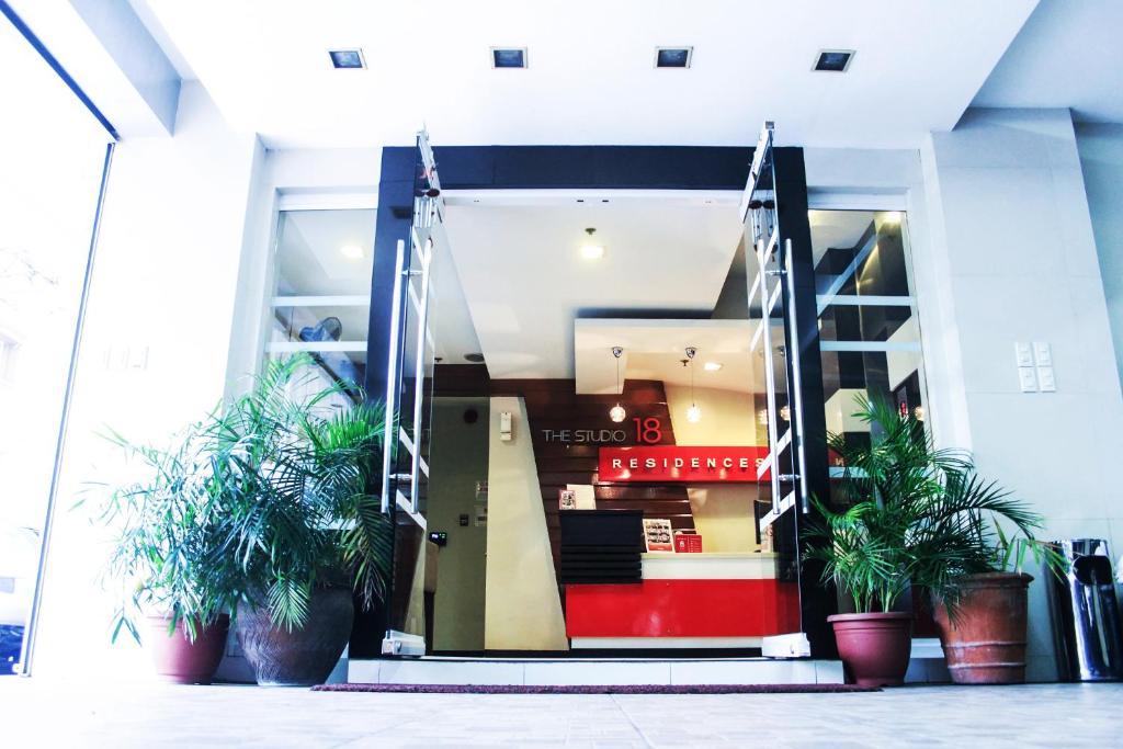 una puerta delantera de un edificio con macetas en The Studio 18 Residences, en Manila