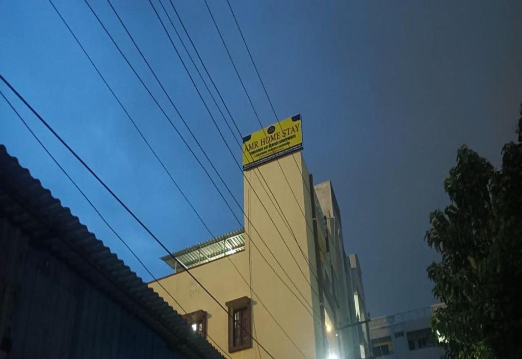 ティルパティにあるHotel O AMR Home Staysの上に黄色い看板がある建物