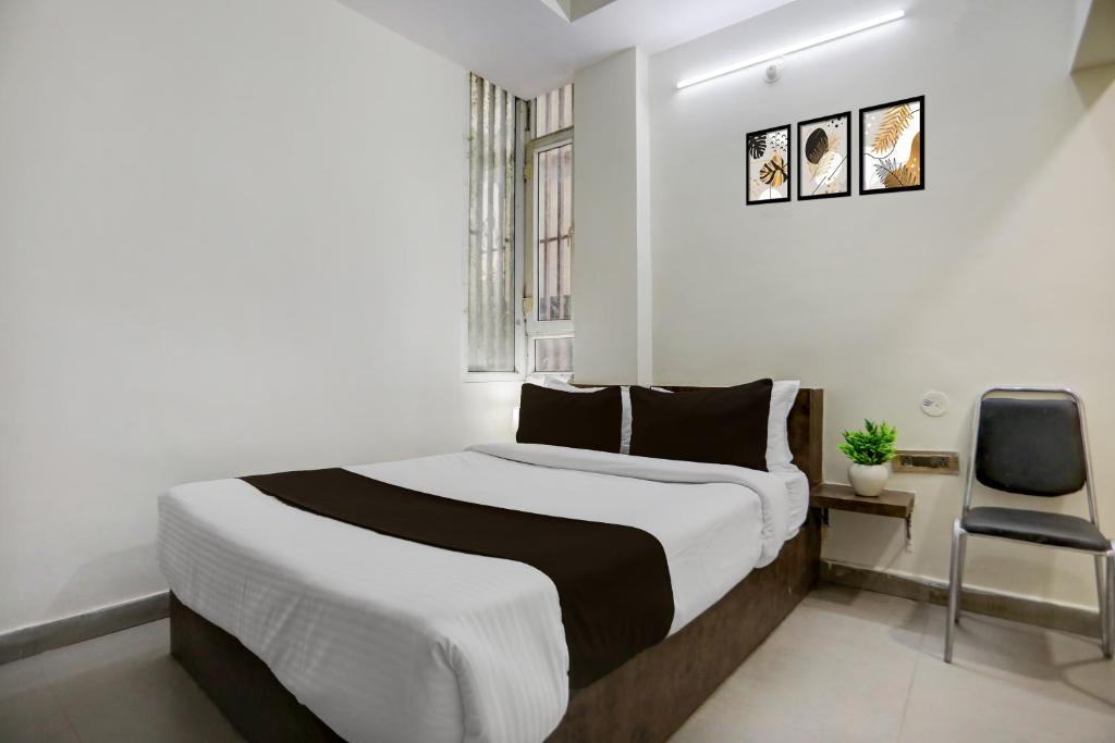 a bedroom with a large bed in a white room at Hotel O Shad Residency in Patna