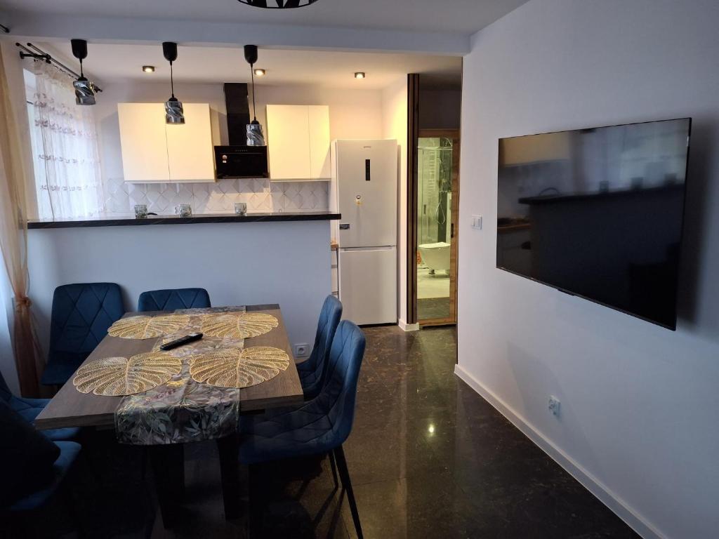 ein Esszimmer mit Tisch und Stühlen und eine Küche in der Unterkunft Apartament pod Czarną Górą in Stronie Śląskie