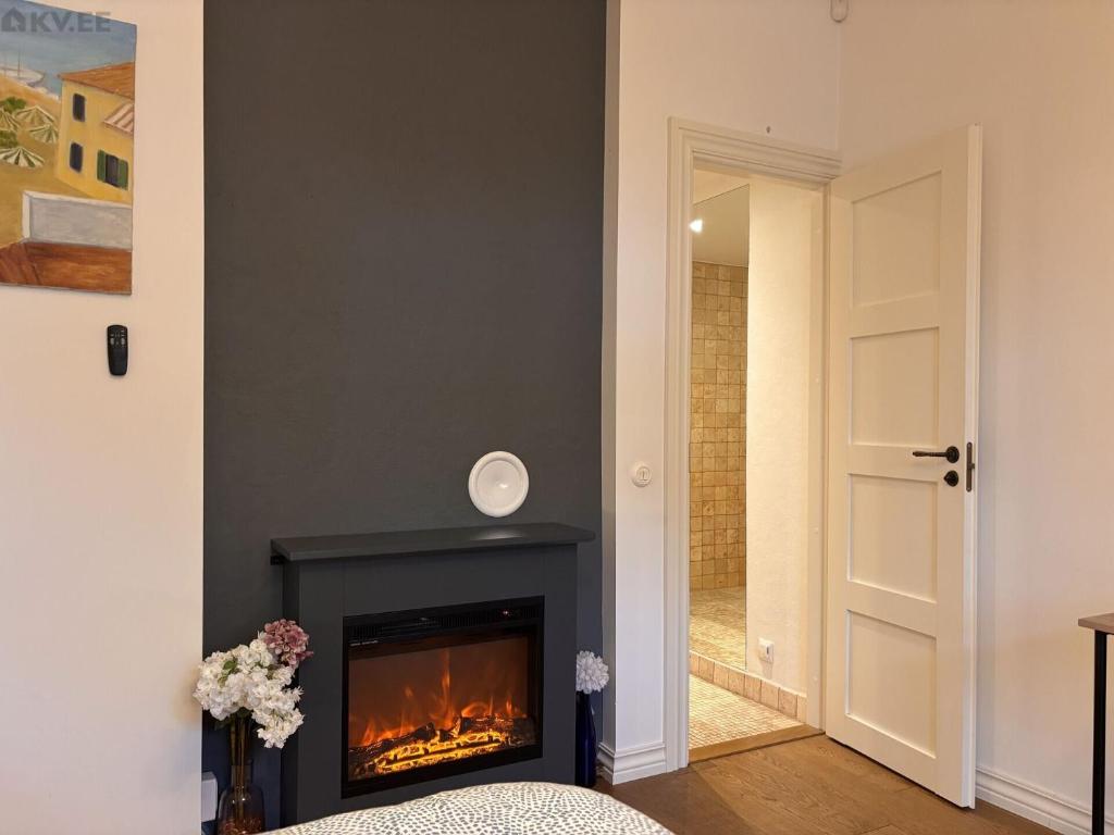 een woonkamer met een open haard en een deur bij Free Parking l Electric Chimney l Everything nearby in Pärnu
