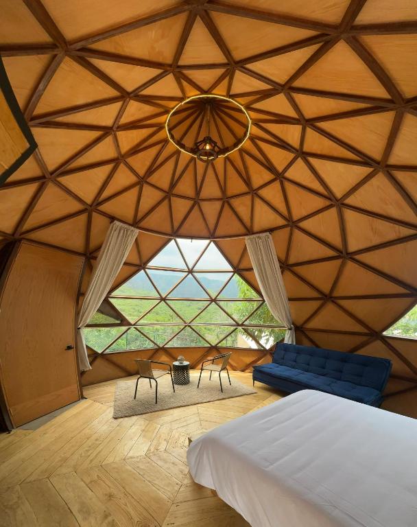 a room with a bed and chairs in a yurt at Gaiatri Holistic Glamping in Tepoztlán