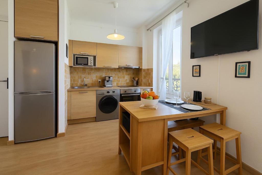 a kitchen with a refrigerator and a table with chairs at Côté Vieil Antibes in Antibes