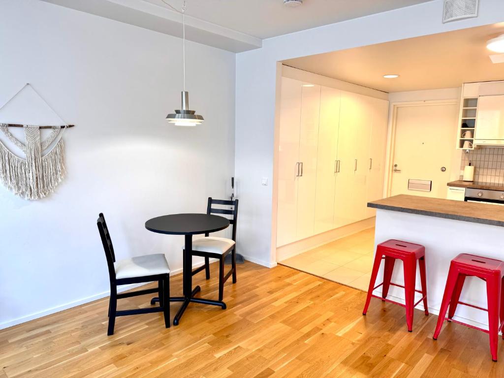 a kitchen and dining room with a table and red stools at Central Suite with Balcony in Helsinki
