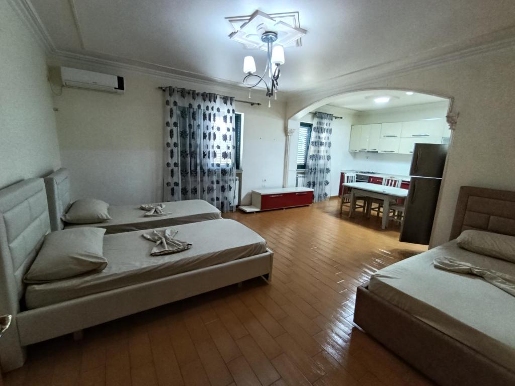 a room with two beds and a kitchen with a table at Northern Lane in Shkodër