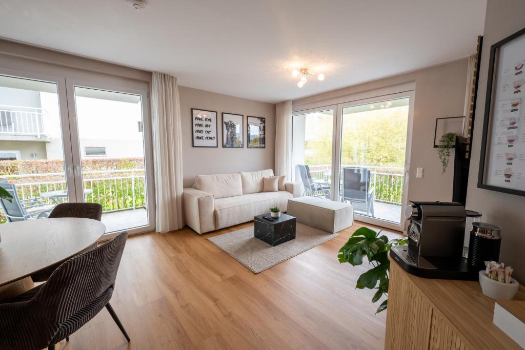 a living room with a couch and a table at Modernes Apartment - Basel, Kur & Golf in Bad Bellingen