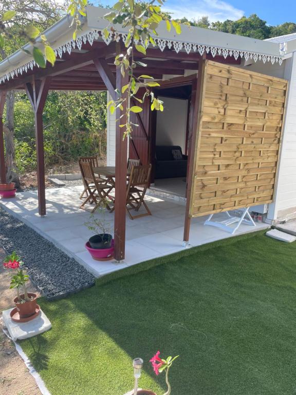 a pergola with a table and chairs on a lawn at Les gîtes Lanmou 2 in La Désirade