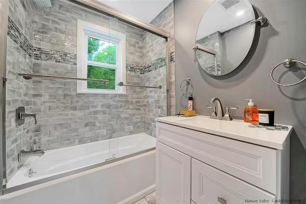 a bathroom with a sink and a tub and a mirror at New Leeds listing Near Graces diner and Hudson! in Catskill