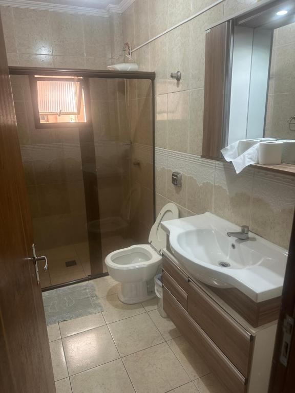 a bathroom with a toilet and a sink and a shower at Apartamentos Nadai 302 in Foz do Iguaçu