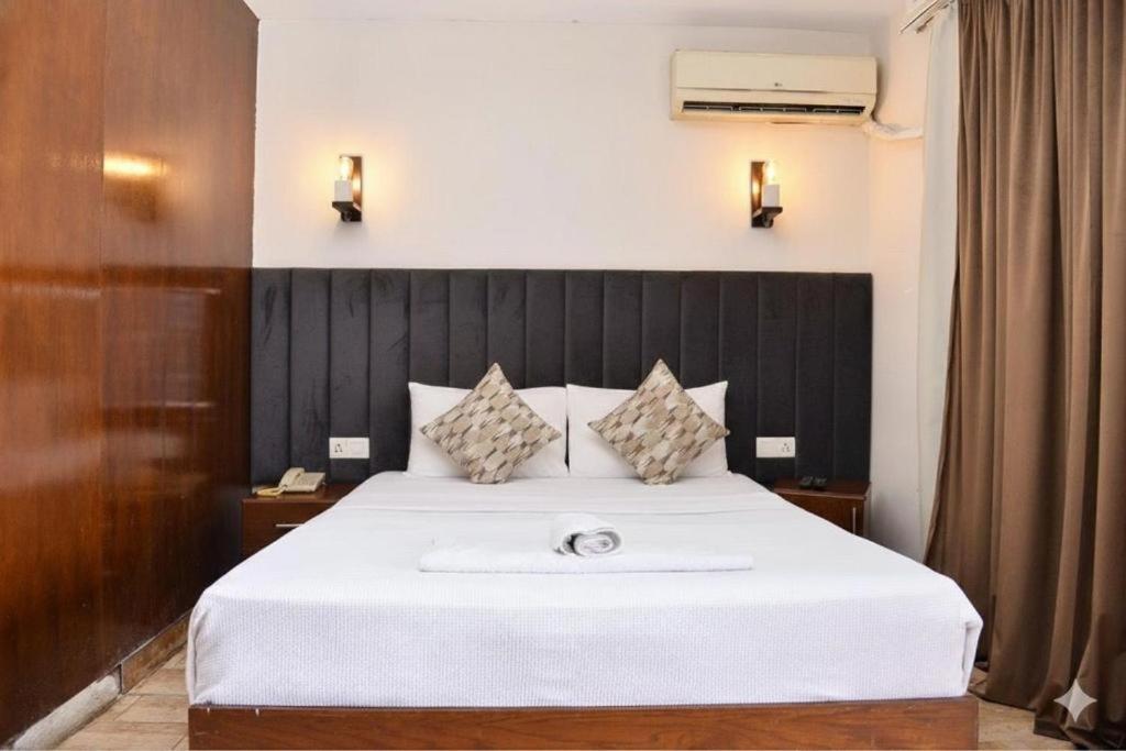 1 dormitorio con cama blanca y cabecero negro en Lorenda hotel, en El Cairo