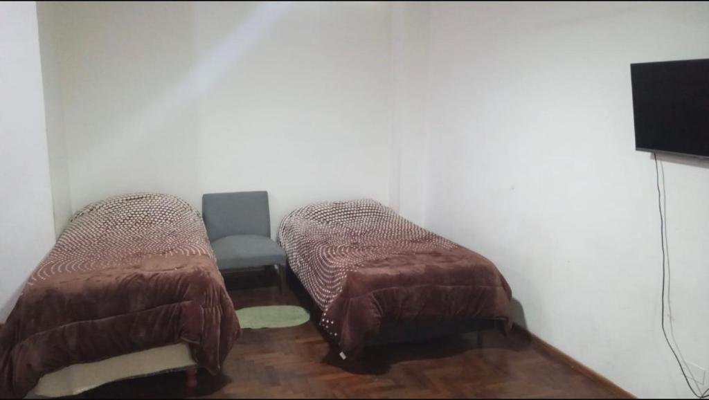 een kamer met 2 bedden en een tv. bij Alquiler temporal in Cordoba