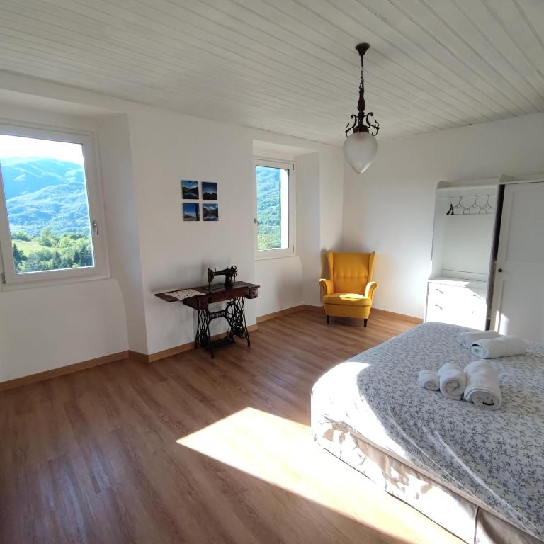 a bedroom with a bed and a desk and a window at Charme nel borgo - Appartamento Lina in Corniglio