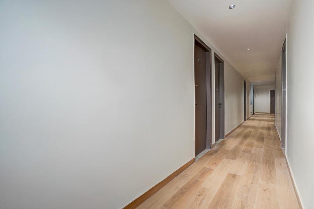 an empty hallway with white walls and wood floors at Townhouse DSIDC Bawana Formerly Kanhaiya Residency in Bawāna