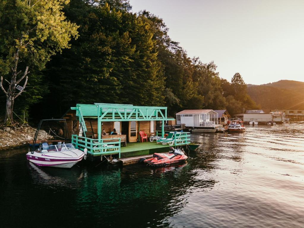 a house boat on a dock on a river at Casuta Verde Bicaz in Bicaz