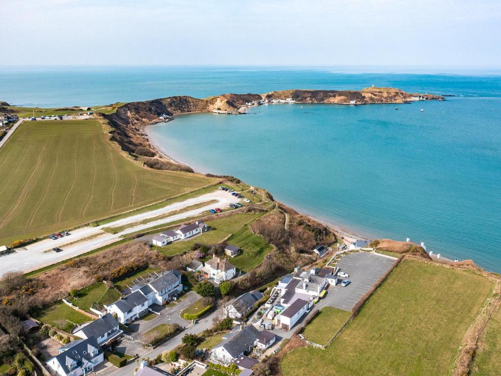 an aerial view of a beach with houses and the ocean at Min Y Traeth By The Beach in Morfa Nefyn