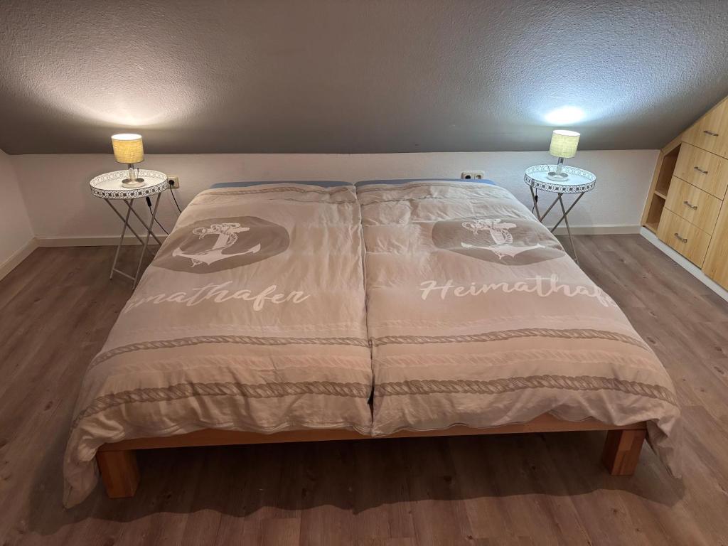 a bed in a room with two end tables at Ferienhaus Heimathafen Neßmersiel in Neßmersiel