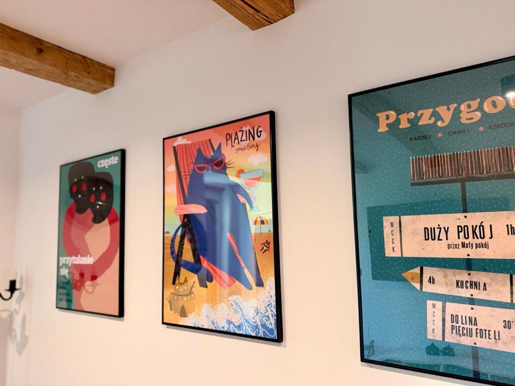 three posters hanging on a wall at Blisko in Kuźnica