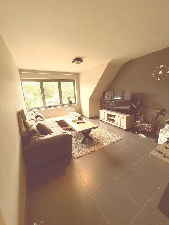 a living room with a couch and a table at Modern Duplex Apartment with terrace view in Stekene