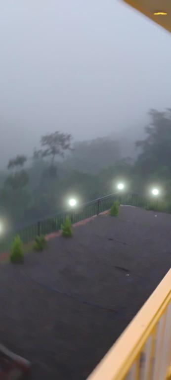 Ein nebliger Parkplatz mit einem Baum im Hintergrund in der Unterkunft Grand Sapphire Resorts & Travels Idukki in Idukki