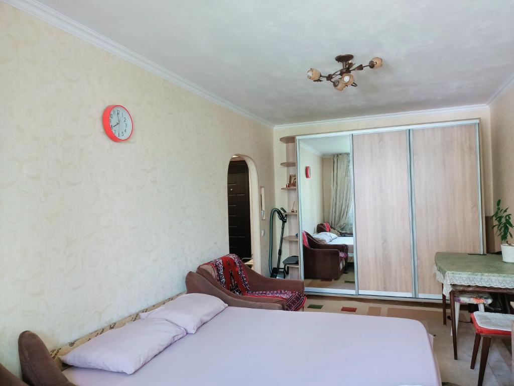 una camera da letto con un letto e un orologio sul muro di Genius a Chişinău