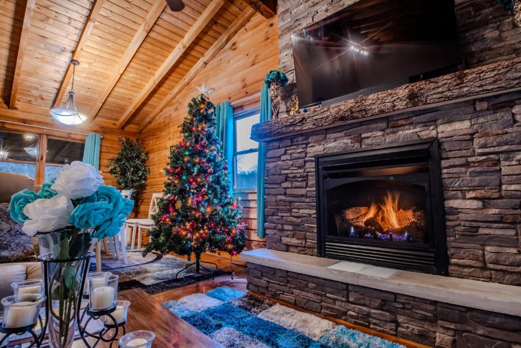 ein Wohnzimmer mit einem Kamin und einem Weihnachtsbaum in der Unterkunft Ascension Cabin - hot tub, fire pit, babbling brook in Mount Nebo