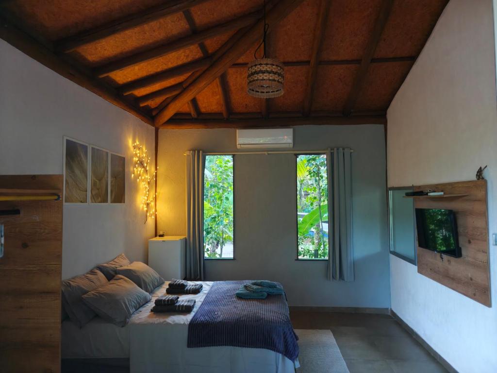 ein Schlafzimmer mit einem Bett und einem großen Fenster in der Unterkunft Casa Boa Energia in Barra Grande