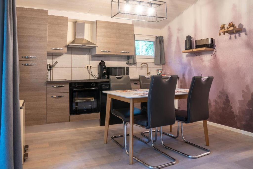 a kitchen with a wooden table and chairs at Sakurahuisje in Lanaken