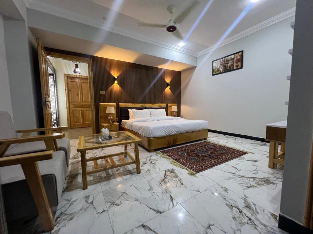 a bedroom with a king sized bed and a table at Nawab's Hotel Balakot in Bālākot