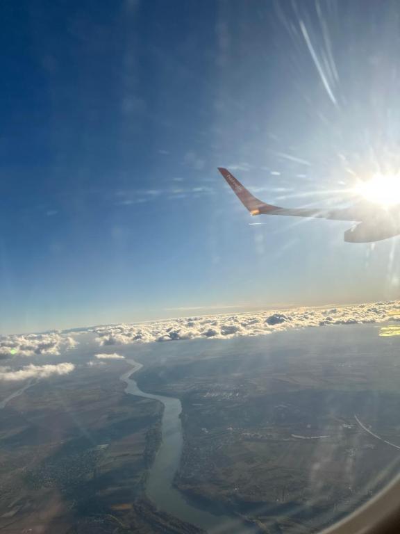 a view of the wing of an airplane flying over a river at Maison in Vétroz