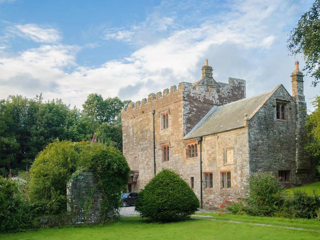 an old stone building with a tower on top at Whitehall Pele Tower in Mealsgate