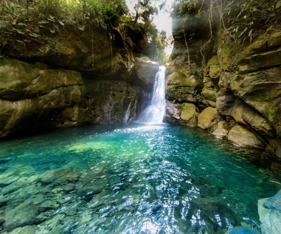 a pool of water in front of a waterfall at Pousada Magia da Aldeia in Silva Jardim