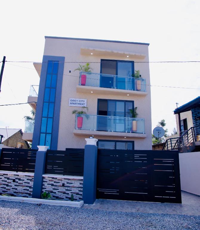 a building with a black gate and a balcony at GreyCity Apartments in Accra