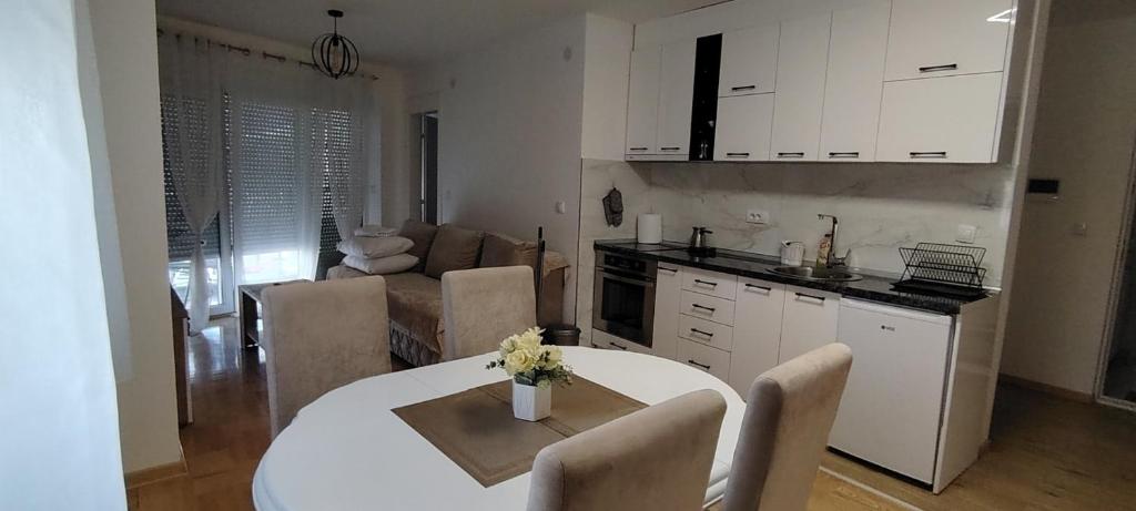 a kitchen and living room with a table and chairs at Apartman Ciric in Vrnjci