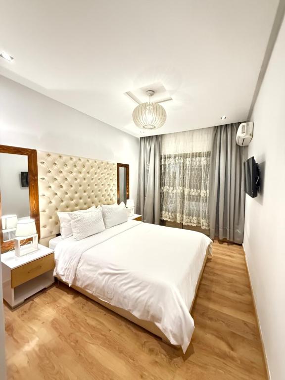 马拉喀什Appartement haut standing的卧室里有一张白色的大床和一扇窗户