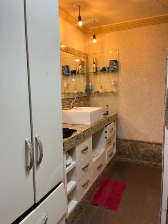 een badkamer met een wastafel en een spiegel bij Casa Completa no Centro in Porto Seguro