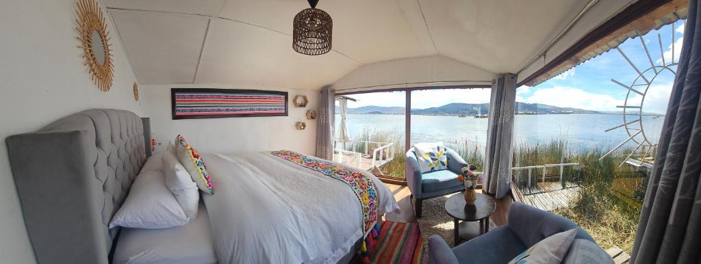 Un dormitorio con una cama y vista al agua. en Titicaca Floating Lodge, en Puno