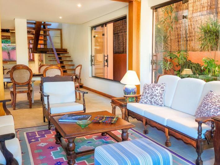 ein Wohnzimmer mit Sofa, Stühlen und einem Tisch in der Unterkunft Luxo e requinte em um só lugar casa Santo Antônio in Ilhabela