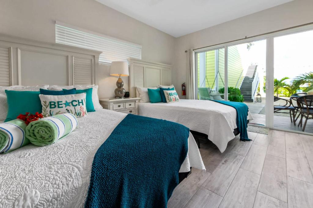 a bedroom with two beds and a large window at The No Problem at Cottages in Sand Bluff